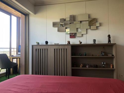 une chambre avec un lit avec une couette rouge et une étagère dans l'établissement Luxury Apartment 4 w Pool, Sea and Mountain Views, à Mandelieu-la-Napoule
