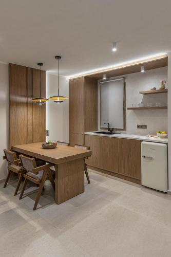 a kitchen with a wooden table and a kitchen with a counter at Scarabeo Suites & Villas Parga in Parga