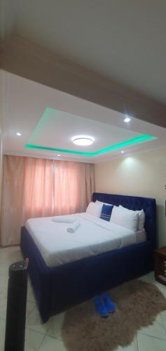 a bedroom with a large bed with a blue headboard at Milimani Luxury Apartments - J1 in Nakuru