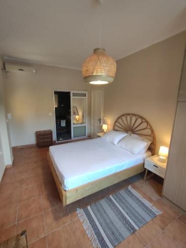 a bedroom with a large white bed in a room at Villa Loula google it in Lygia