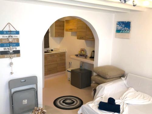 a living room with an archway and a kitchen at Windmill House Mykonos in Megali Ammos