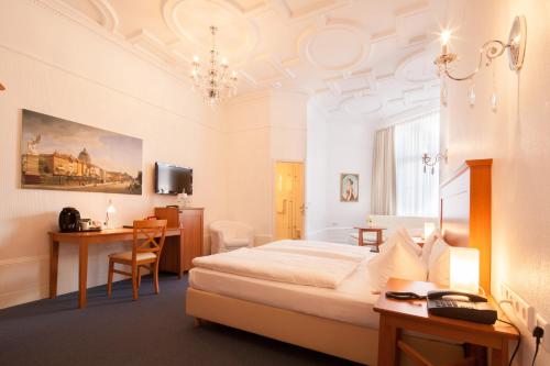 ベルリンにあるホテル ブランディーズ アン デア メッセのベッド、デスク、テーブルが備わる客室です。