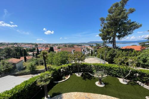 a garden with a view of a city at Apartment Olive Malinska - Panoramic Sea View in Malinska