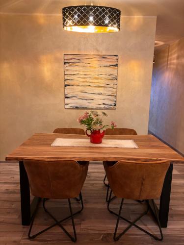 a wooden table with chairs and a vase of flowers on it at Amor, flat with private hot tub, breathtaking views and free parking in a garage, bookable all year round, Also take a look at our flat Coccolina in Rabac