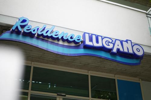 a sign on the side of a building at Lugano Residence in Rimini