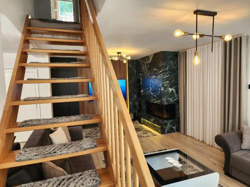 a wooden staircase in a living room with a fireplace at Villa Hoxha Brezovicë in Brezovicë
