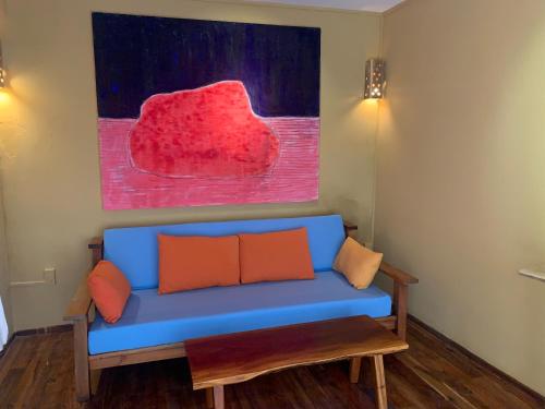 a blue couch in a room with a painting at Eco Lagoon in Phu Quoc