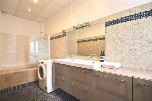 une salle de bain avec un lavabo et une machine à laver dans l'établissement Gambetta family pad, à Paris
