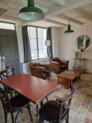 a living room with a table and chairs at La Maison du Pêcheur in Verdun-sur-le-Doubs