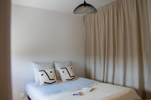 une chambre avec un lit avec des draps blancs et des oreillers dans l'établissement Hélios - Appartement lumineux 65 m2, à Annecy