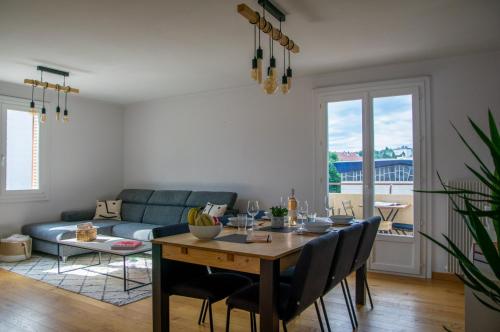un salon avec une table et un canapé bleu dans l'établissement Hélios - Appartement lumineux 65 m2, à Annecy