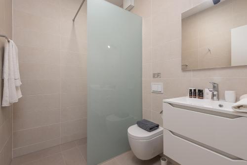 a white bathroom with a toilet and a sink at Korcula Hill in Korčula