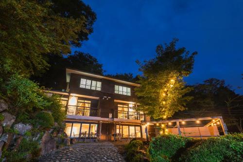 a large house with lights on it at night at SPRINGS VILLAGE HAKONE Glamping Resort in Hakone