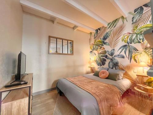 - une chambre avec un lit et un mur orné d'une fresque murale dans l'établissement Studio Aimer hyper centre, à Cognac