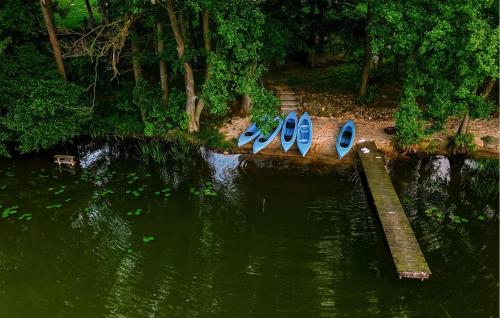 a row of blue boats sitting in the water at Nice Home In Insko With Sauna in Ińsko