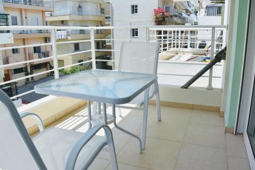 a glass table and two chairs on a balcony at B3 Irene in Thérissos