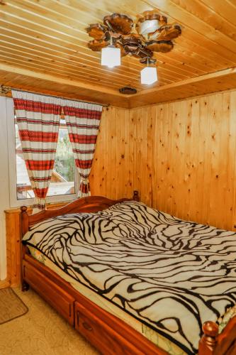 a zebra print bed in a room with a window at Котедж "У Бойка" in Mykulychyn
