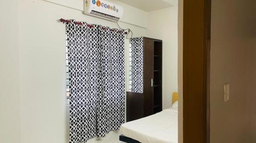 a bedroom with a bed and a black and white curtain at Rajamandiram 3BHK AC,Near Sree Padmanabhaswamy Temple, Trivandrum Central in Trivandrum