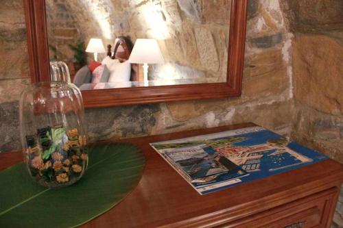 a table with a mirror and a vase on it at Harritarte Getaria in Getaria