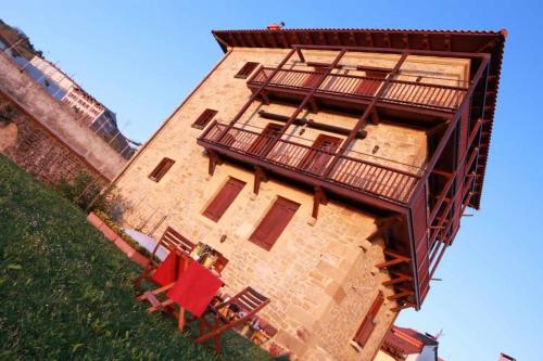 a building with a balcony and tables and chairs at Harritarte Getaria in Getaria
