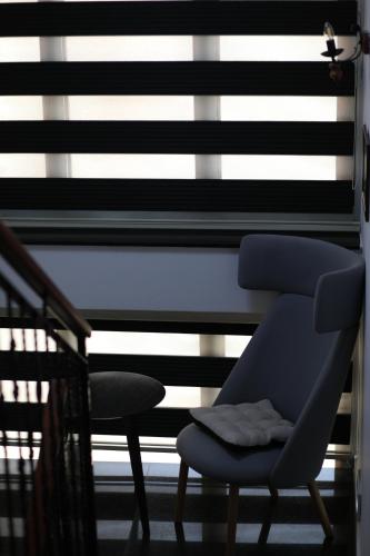 a blue chair sitting in front of a window at Bruti Hotel in Prizren