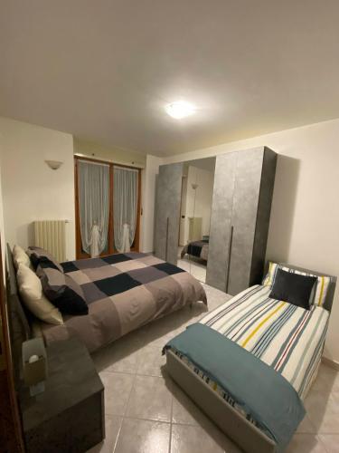 a bedroom with two beds and a couch at Casa Luelda in San Maurizio Canavese