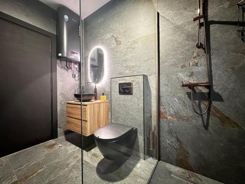 a bathroom with a black toilet and a sink at Sunshine Apt in Central Sliema in Sliema