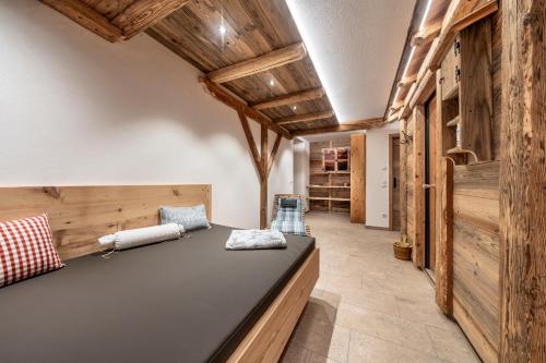 a large room with a couch in a room with wooden walls at Pension Lenz´n am Christlhof in Lenggries