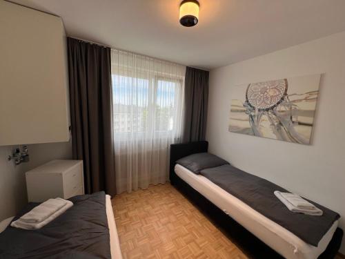 a bedroom with two beds and a window at rs44 Apartments über den Dächern von Bregenz in Bregenz