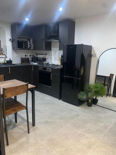 a kitchen with black cabinets and a table with a plant at The Courtyard - By Casa Living in Canley
