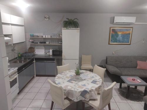 a kitchen and a living room with a table and chairs at Sandra Apartmani 2 in Zaostrog