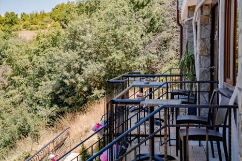 a balcony of a house with chairs and trees at Apartments BRAVO in Ohrid