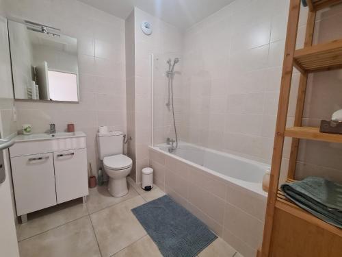 a bathroom with a toilet and a tub and a sink at Maison Marsane côte Landaise in Lit-et-Mixe
