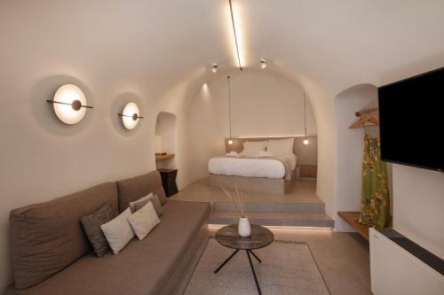 a living room with a couch and a bed at Utopia Suites Santorini in Karterados