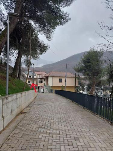a brick walk way with a fence and a tree at Duka Apartment in Librazhd