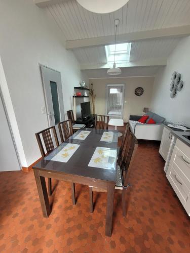 une salle à manger avec une table, des chaises et un canapé dans l'établissement Dolce Vita, à Notre-Dame-de-Monts