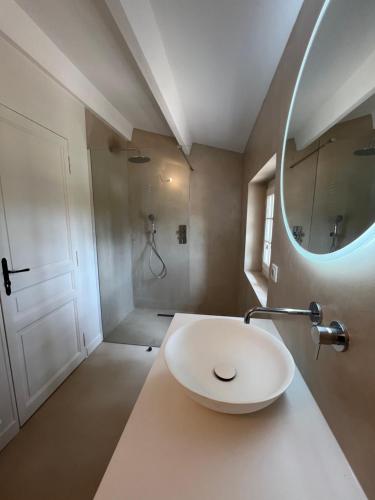 Un baño con un lavabo blanco y un espejo. en LAVENINE a Modène, en Modène
