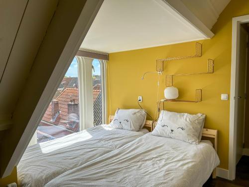 a bedroom with a bed with a large window at Luxe familie appartement bij de Waegh Dokkum in Dokkum