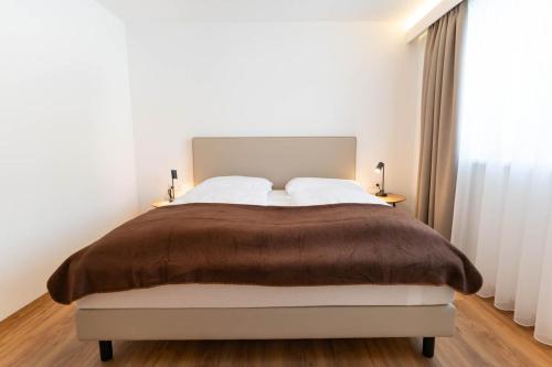 a bedroom with a large bed and a window at Waldrand Apartments in Ramsau am Dachstein
