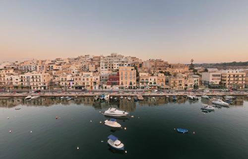 a group of boats in a body of water with buildings at Casa Rosanna Malta B&B Adults only 16 plus in Marsaskala