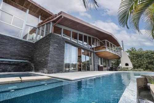 a house with a swimming pool in front of a house at Casa Brisas Del Mar- Luxury 6 Bedroom Ocean View Home in Puerto Viejo