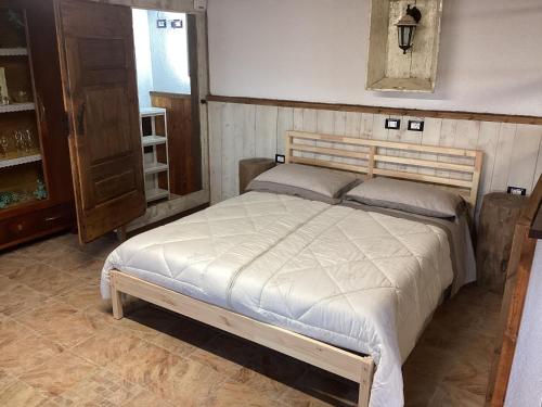 a bedroom with a bed with a wooden head board at Casa Scarbini in Savogna