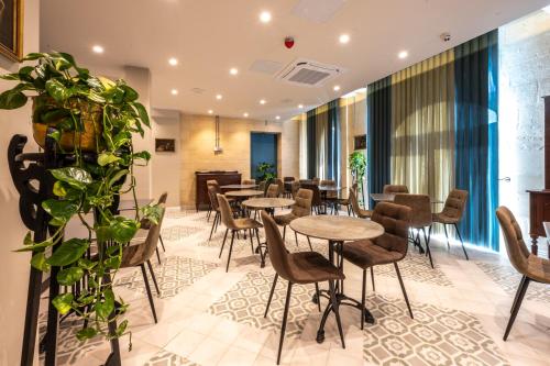 a restaurant with tables and chairs and plants at Casa Rosanna Malta B&B Adults only 16 plus in Marsaskala