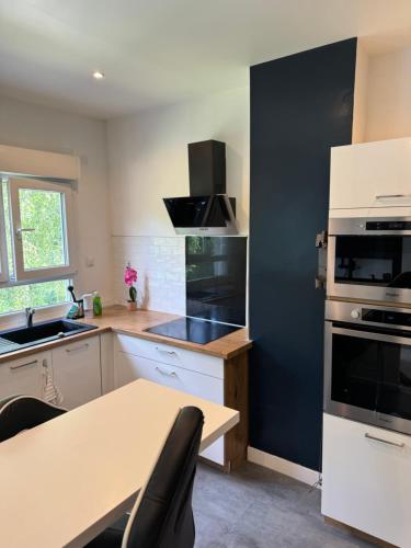 une cuisine avec une table et un mur noir dans l'établissement Appartement proche de Tours, à Saint-Avertin