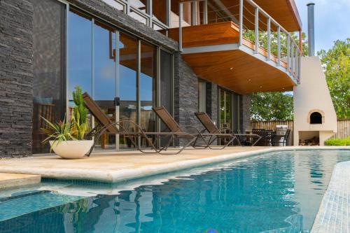 a house with a swimming pool and a balcony at Casa Brisas Del Mar- Luxury 6 Bedroom Ocean View Home in Puerto Viejo