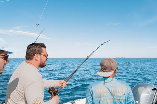 three men fishing on a boat in the ocean at Casa Brisas Del Mar- Luxury 6 Bedroom Ocean View Home in Puerto Viejo
