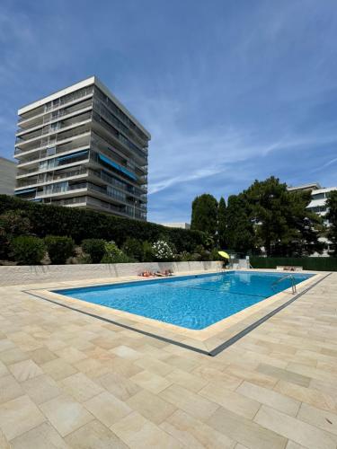 une piscine devant un grand immeuble dans l'établissement Studio neuf avec terrasse vue mer, à Cannes