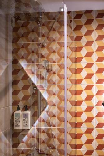 a shower with a glass door with two soap bottles at Casa Rosanna Malta B&B Adults only 16 plus in Marsaskala