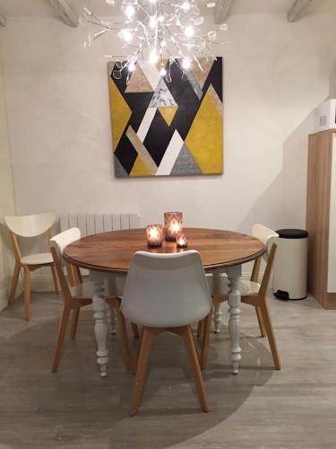 une table à manger avec des chaises et un tableau dans l'établissement Gite Marisan 10 minutes du Futuroscope ,Aquascope et Salle de spectacle Arena, à Beaumont