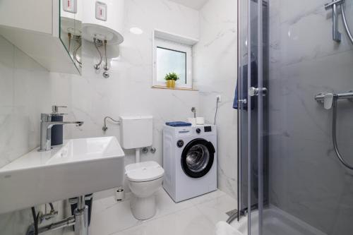 a bathroom with a toilet and a washing machine at PODVEZANEC in Dramalj